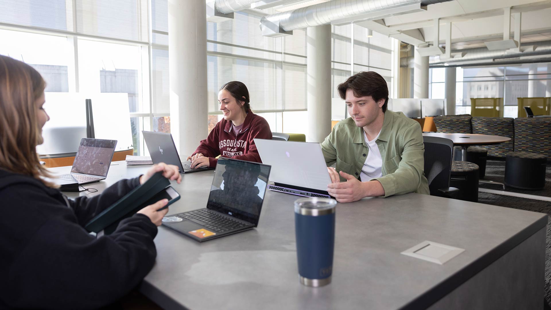 Three students studying at a table in Meyer Library.